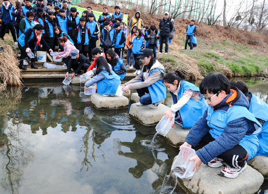 한국지엠(GM)이 지난 16일 '2019에코 프렌들리 캠페인' 발대식을 열고 캠페인 시작을 알리는 봄맞이 환경정화 활동에 나섰다. 사진은 행사 참가자들이 부평 굴포천에서 미꾸라지를 방류하고 있는 모습. <한국지엠(GM) 제공>